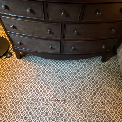 Sale Photo Thumbnail #65: Dark stained bowfront dresser with seven drawers and simple wooden knobs, sitting on patterned carpet.