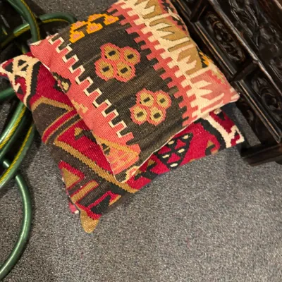 Sale Photo Thumbnail #27: Pair of hand-woven kilim throw pillows featuring vibrant tribal geometric patterns in shades of red, brown, and cream.