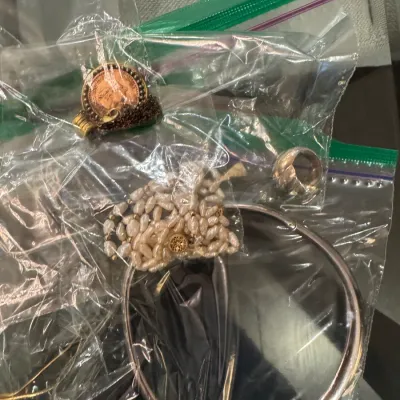 Sale Photo Thumbnail #10: Assorted estate jewelry in plastic storage bags, including a rice pearl strand bracelet, a silver-tone bangle, a ring, and a coin pendant.