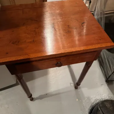 Sale Photo Thumbnail #62: Traditional wooden side table with a single drawer and turned legs, featuring surface wear and water rings on the top finish.