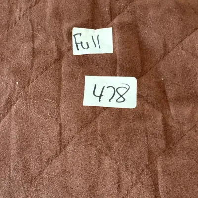 Brown quilted full-size mattress pad or bedding protector with a handwritten size label.