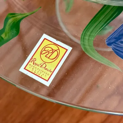 Detail shot of hand-painted floral glassware featuring an original Royal Danube sticker label.