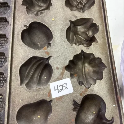 Cast iron autumn fruits and leaves muffin pan with eight detailed impression molds, in well-seasoned condition.