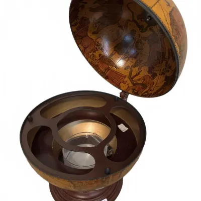 Vintage Italian-style bar globe opening to reveal bottle and glass storage compartments with celestial illustrations inside the dome.