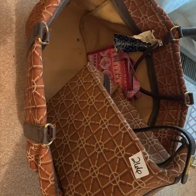 Vintage brown patterned luggage set including a large travel tote and matching handbag, featuring geometric embroidery and dark trim.