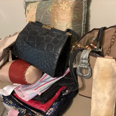 Collection of women's accessories including a black crocodile-embossed leather handbag, a canvas tote, silver-tone woven belt, and...
