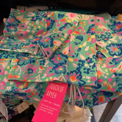 Folded floral print garment from Touch of Aryeh featuring UPF 50+ sun protection and new with tags condition.