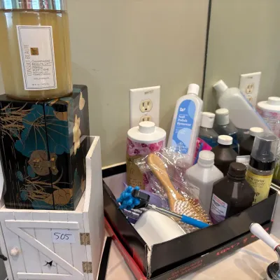 Assortment of personal care products and toiletries alongside decorative wooden jewelry boxes.