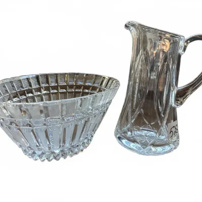 Two vintage clear cut crystal tableware pieces, including a crosshatched pattern bowl and a tall pitcher with an arching motif.