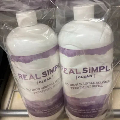 Two 32 fl oz bottles of Real Simple Clean lavender-scented no-iron wrinkle release treatment refills, sealed together in clear plastic...