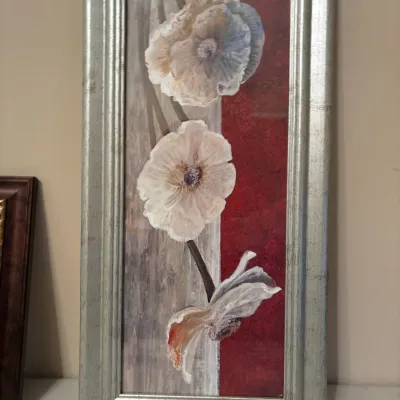 Contemporary framed floral wall art depicting white and soft blue blossoms against a split neutral and red background, set in a metallic...