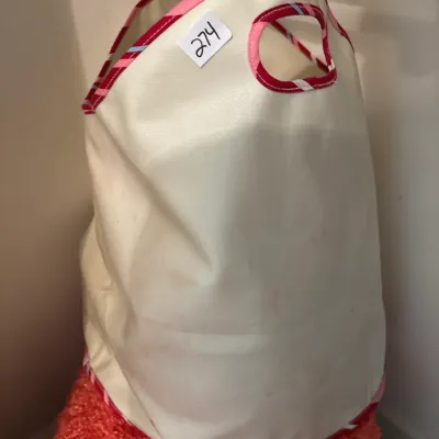 Tall cream canvas storage bag or hamper featuring pink striped fabric trim and cutout handles.