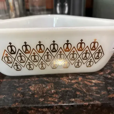 Vintage white milk glass divided casserole dish featuring a gold crown and diamond geometric pattern.