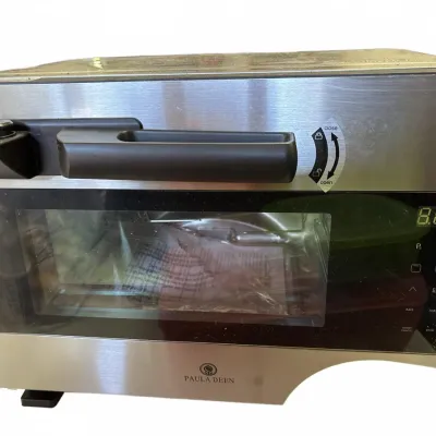 Paula Deen stainless steel countertop air fryer oven featuring a digital display and glass viewing window.