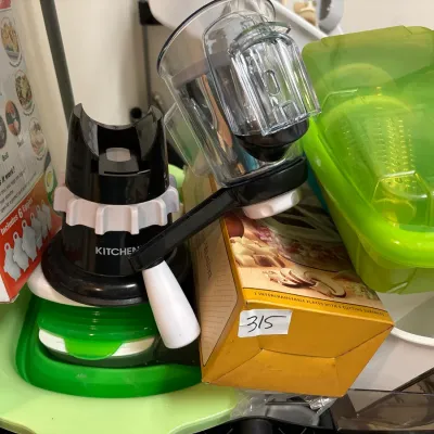 Assorted modern kitchen gadgets and food preparation accessories, including a manual rotary grater, Eggies hard-boiled egg system in box,...