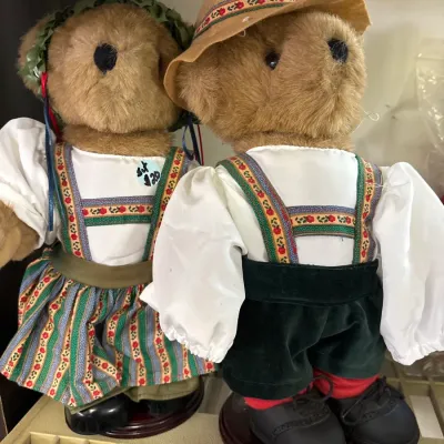 Pair of vintage teddy bears dressed in traditional German Alpine trachten attire, mounted on wooden display stands.