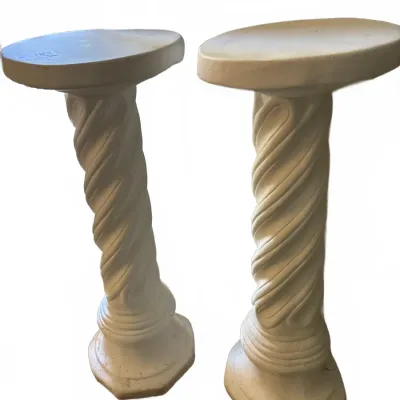 Pair of white classical-style spiral column pedestals with flat oval tops and molded bases.