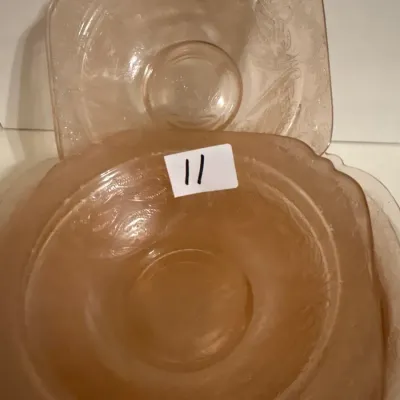 Set of vintage pink depression glass bowls in a square-rimmed shape with embossed scrolling floral pattern.