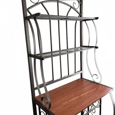 Black metal wrought-iron style baker's rack featuring decorative scrollwork, two wire upper shelves, a wood-grain counter shelf, and...
