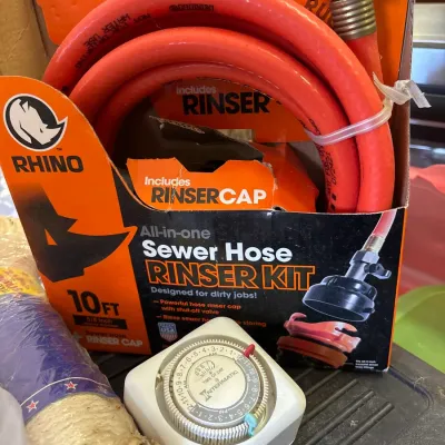 Rhino 10-foot all-in-one sewer hose rinser kit in original packaging, alongside an Intermatic plug-in timer.