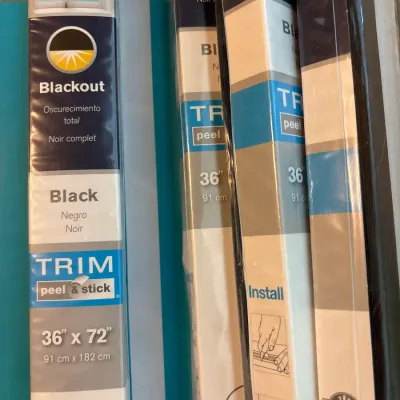 Multiple packages of black TRIM At Home blackout peel-and-stick window shades, measuring 36" x 72".