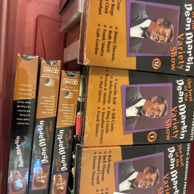 Collection of 'The Best of the Dean Martin Variety Show' VHS tapes stored inside a red plastic tote container.
