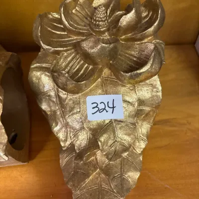 Gold-painted cast resin decorative wall bracket or bookend featuring a blooming magnolia flower with leaf detail.