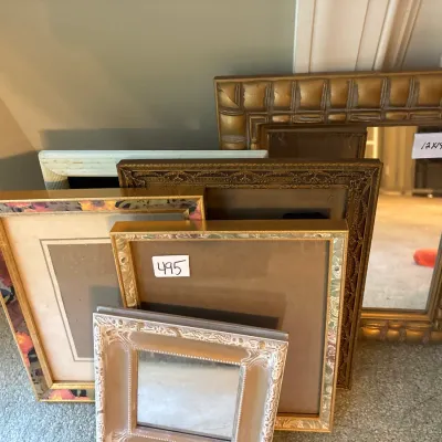Collection of assorted picture frames and small mirrors in gold tone, painted, and floral-bordered styles.
