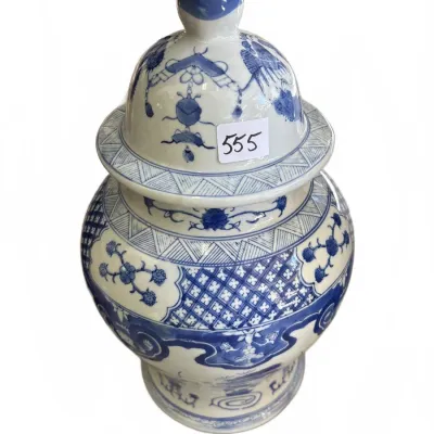 Vintage Asian-style blue and white glazed ceramic ginger jar featuring intricate floral patterns and a pointed finial lid.