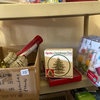 Assortment of holiday decor items, including a Spode Christmas Tree money bank in its original box, clip-on stocking ornaments, and a box...