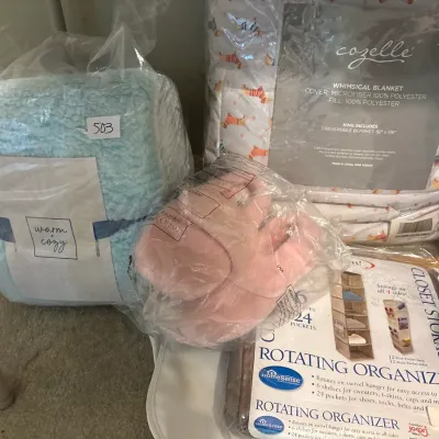 Selection of packaged bedding and home accessories, including a light blue Warm & Cozy plush blanket, a Cozelle king-size whimsical...