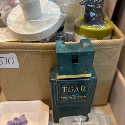 Vintage Tsar de Van Cleef & Arpels Paris eau de toilette bottle displayed alongside assorted toiletries in a fabric basket.