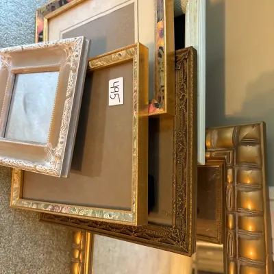 Collection of assorted vintage picture frames and framed mirrors in various sizes, materials, and ornate finishes.