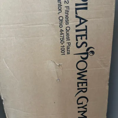 Pilates Power Gym exercise equipment in original cardboard shipping box.