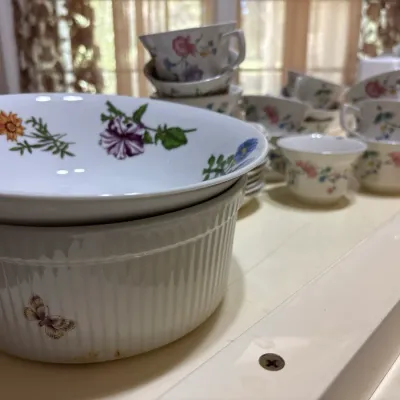 Portmeirion Botanic Garden porcelain soufflé dish and bowl alongside stacked floral teacups.