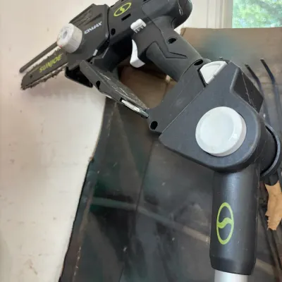 Sun Joe iONMAX cordless pole chain saw attachment, showing light wear from use.