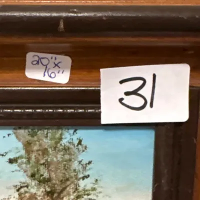 Detail of framed landscape oil painting in a dark wooden frame, measuring 20 inches by 16 inches with estate sale lot sticker 31.