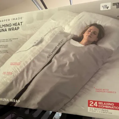 Sharper Image Calming Heat Sauna Wrap in original box, featuring 11 settings for heat and vibration.