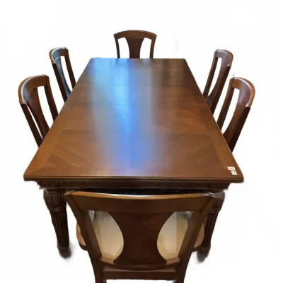 Traditional dark wood dining set featuring a long rectangular table with parquet veneer and six matching splat-back chairs with...