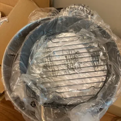 Large round roasting pan or stockpot with an included metal rack, still wrapped in original protective plastic.