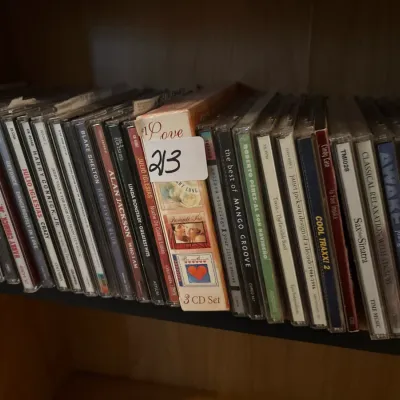 Large collection of compact discs in jewel cases, featuring various pop, country, and vocal artists including Julio Iglesias and Harry...