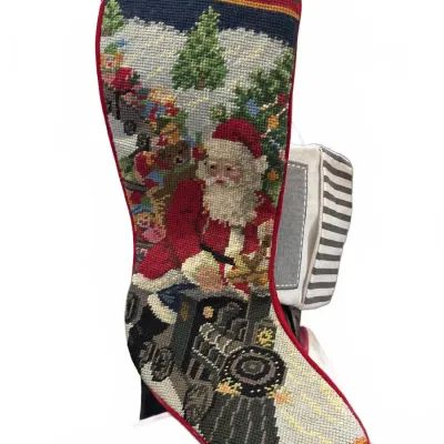 Handcrafted needlepoint Christmas stocking featuring Santa Claus driving a steam train loaded with toys, finished with red piping and a...