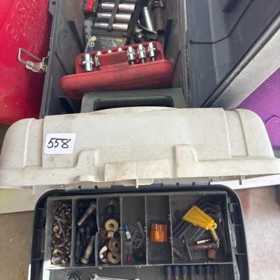 Open plastic toolboxes filled with assorted hand tools, socket sets, hex keys, and small hardware.