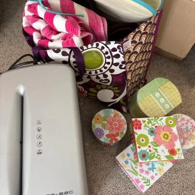 Fellowes Powershred PS-62C paper shredder accompanied by a patterned tote bag containing textiles and various decorative floral boxes.