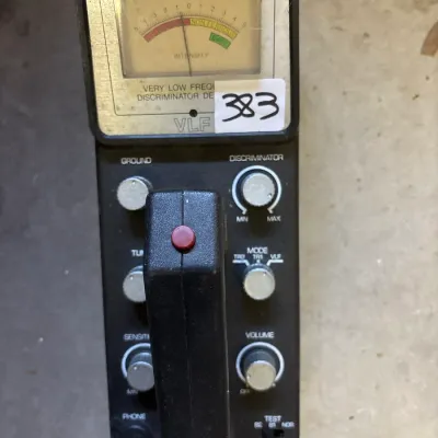 Vintage Radio Shack VLF metal detector control box with analog signal intensity meter and adjustment knobs.