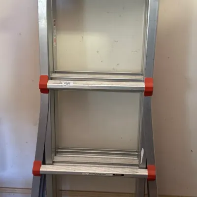 Little Giant folding aluminum multi-position ladder with wheels and orange locking mechanisms.