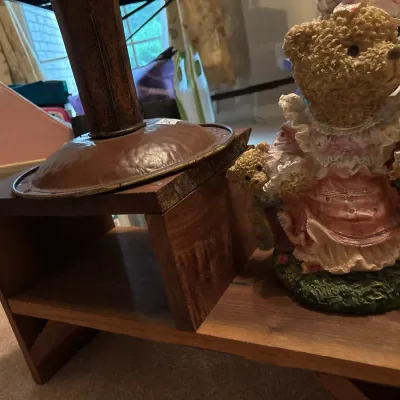 Vintage resin teddy bear figurine displayed alongside a small wooden step riser shelf.