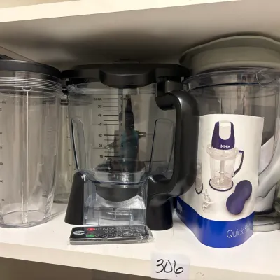 Collection of Ninja blender accessories, including pitcher attachments, single-serve cups, a food processor bowl, and product documentation.
