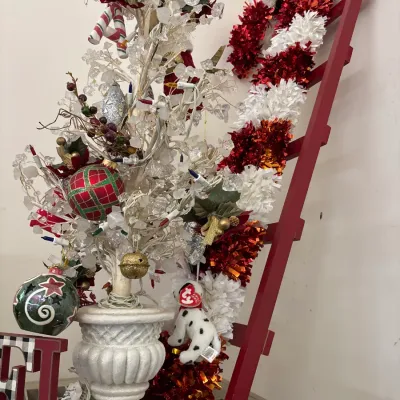 Festive holiday decor assortment, featuring a tabletop clear acrylic twig tree, tinsel candy cane decorations, ornaments, and a red...