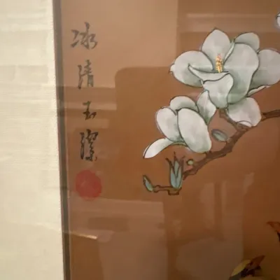 Framed Asian watercolor painting depicting white magnolia blossoms on silk, featuring Chinese calligraphy and artist seal stamp.